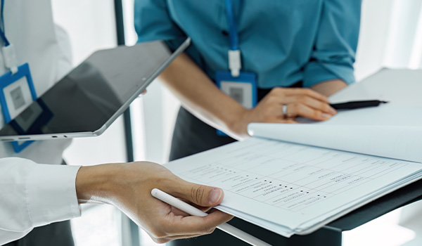 Services-professional-standards-and-Internal-Investigations Professionals reviewing documents and tablets in a modern office setting.